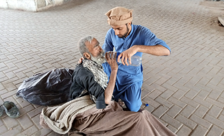 man helping a Syrian refugee by providing water